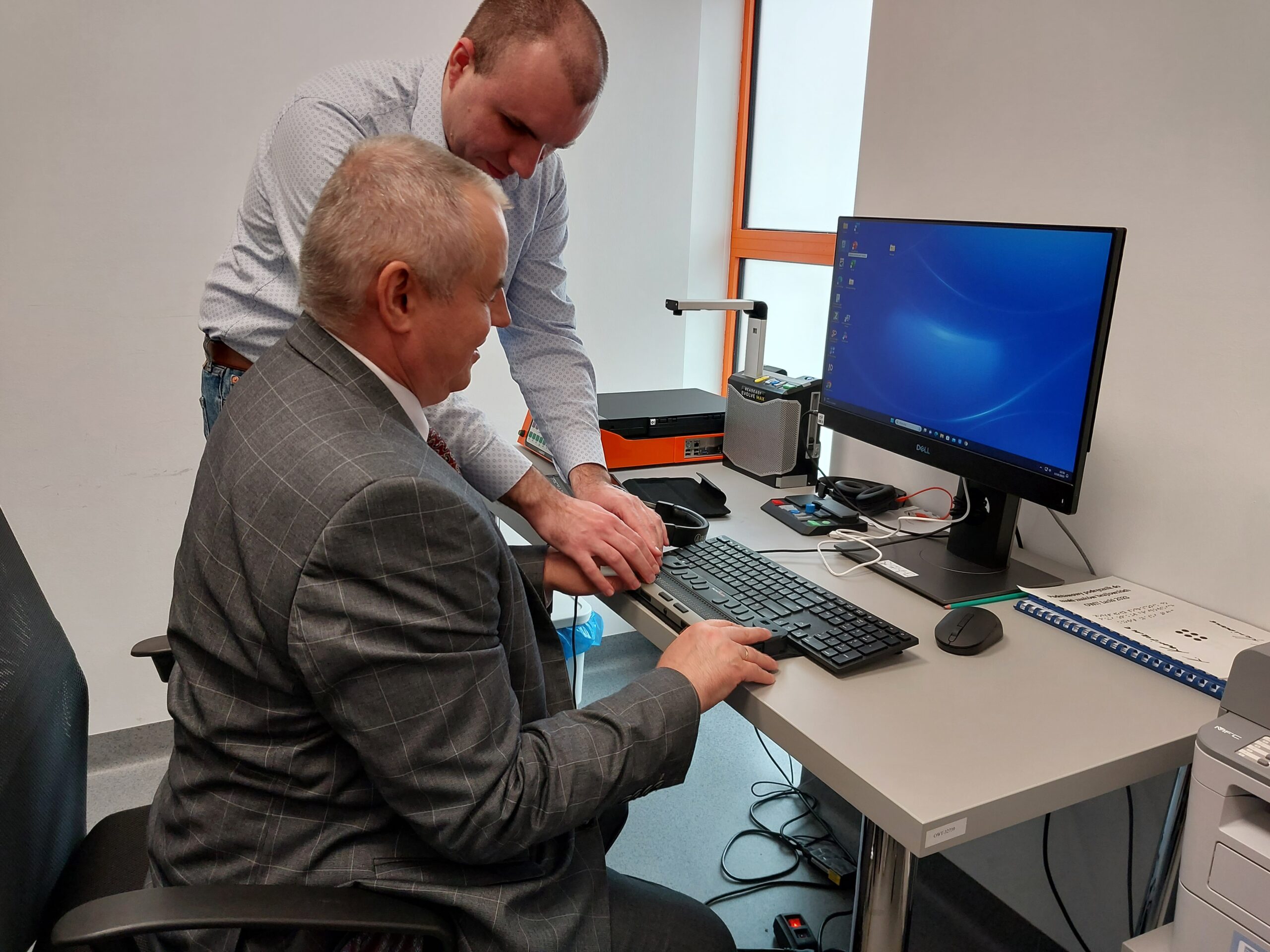 Paweł Wdówik ogląda sprzęt komputerowy.