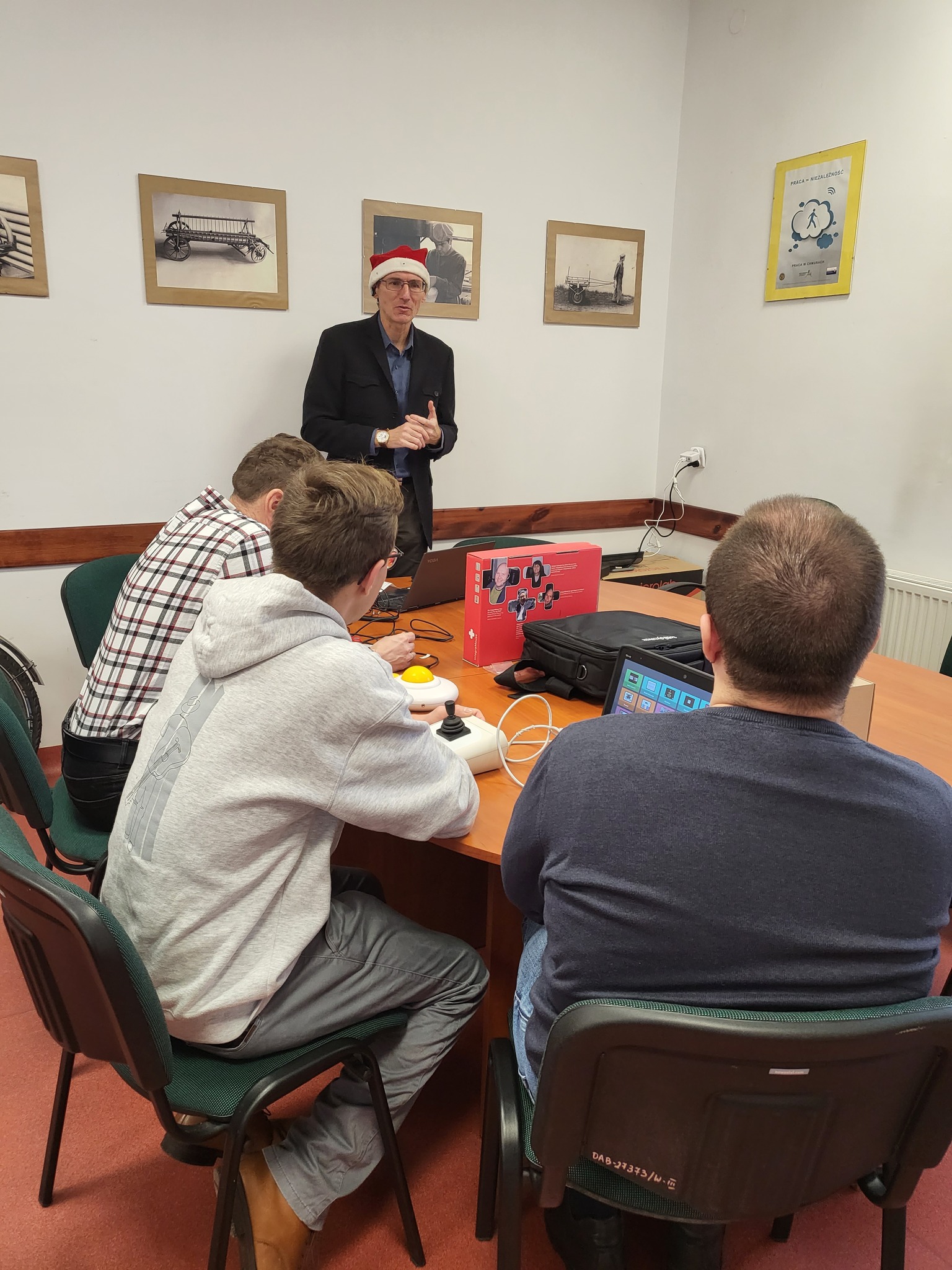 Pracownik w czapce św. Mikołaja opowiada o sprzętach.