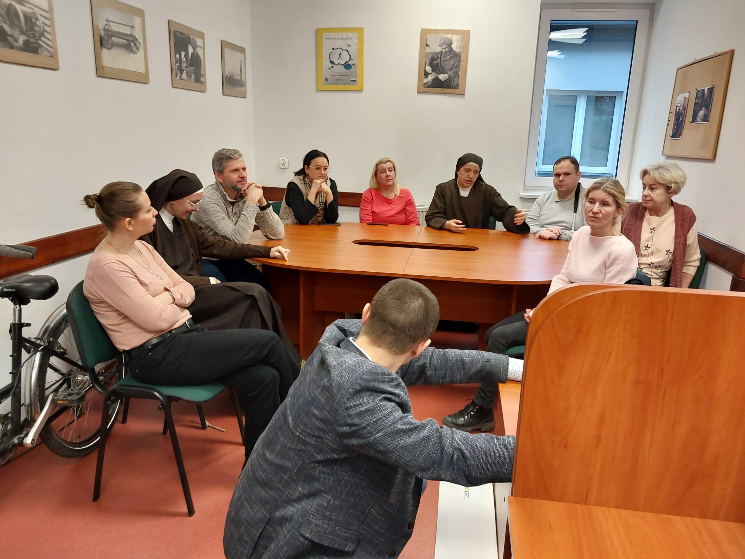 Zebrani uczestnicy siedzą przy stole.