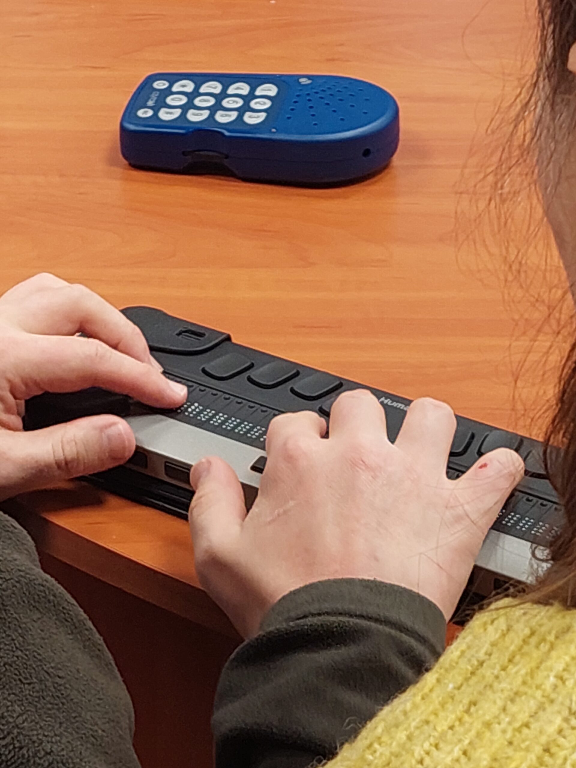 Dłonie na linijce brajlowskiej