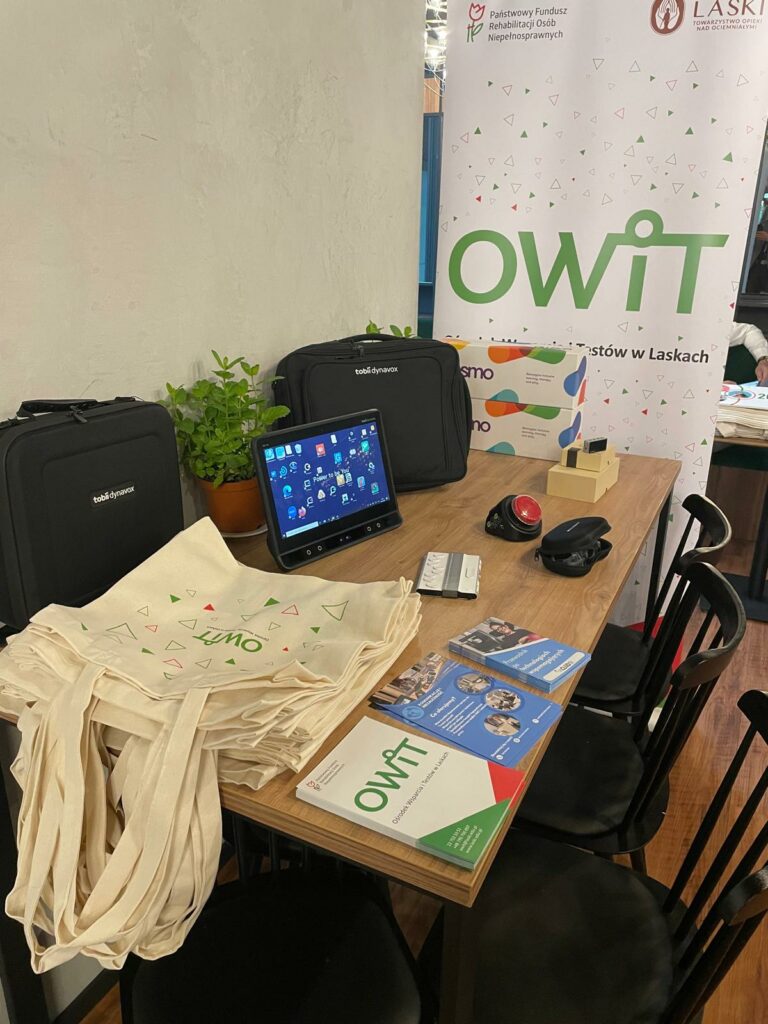 stanowisko OWiT (ulotki, torby, sprzęt, rollup w tle)