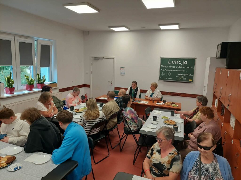 Uczestnicy spotkania siedzący przy stołach